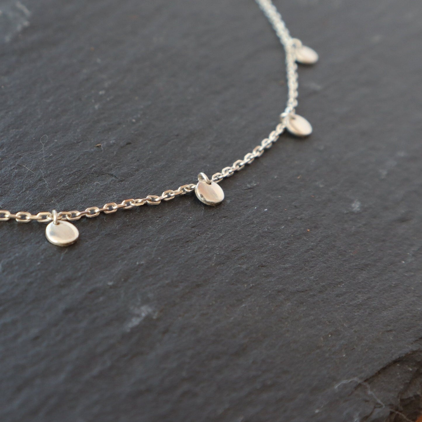 A close up of the sterling silver discs on the satellite choker.