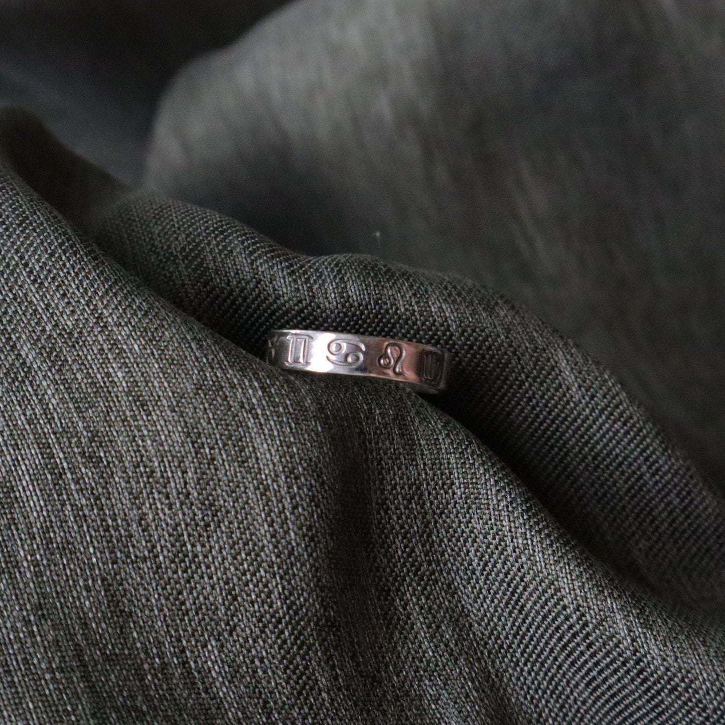 A thick band ring with all 12 zodiac signs stamped onto it.