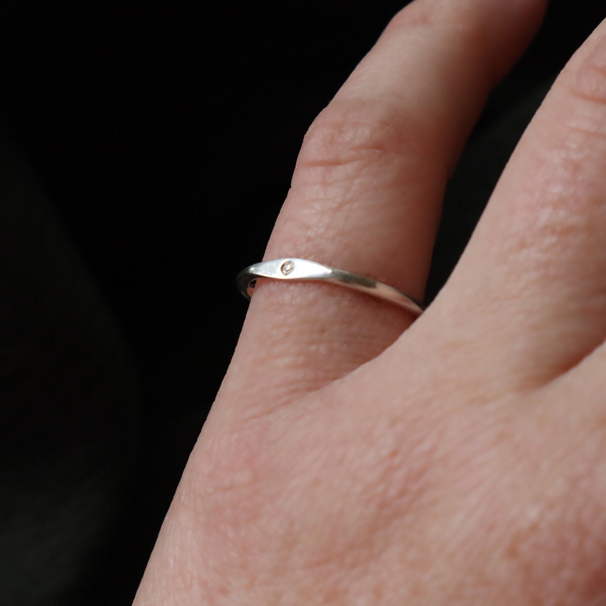 An initial ring worn on the pinky finger