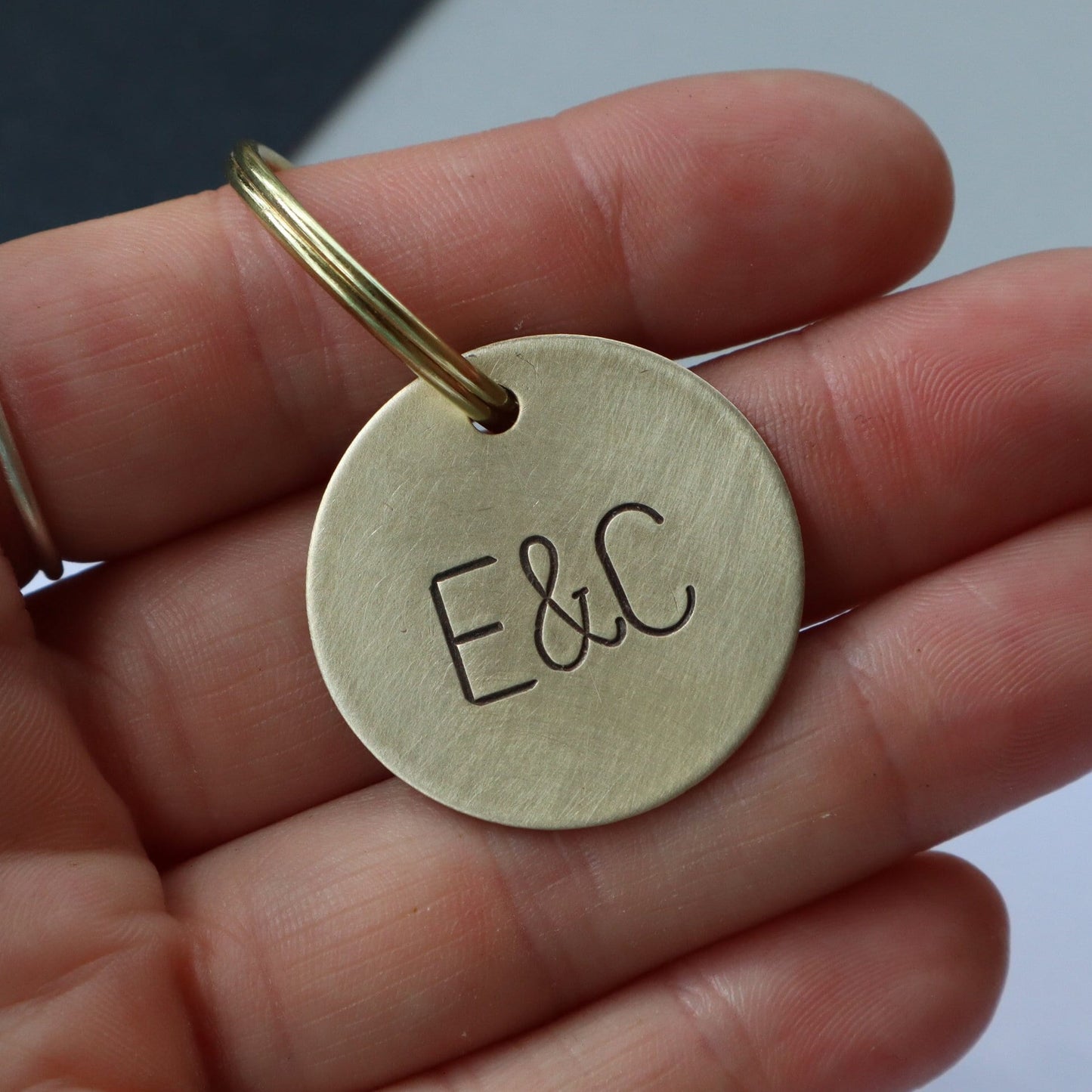 Gold Key Chain with a monogram stamped onto the front of it.