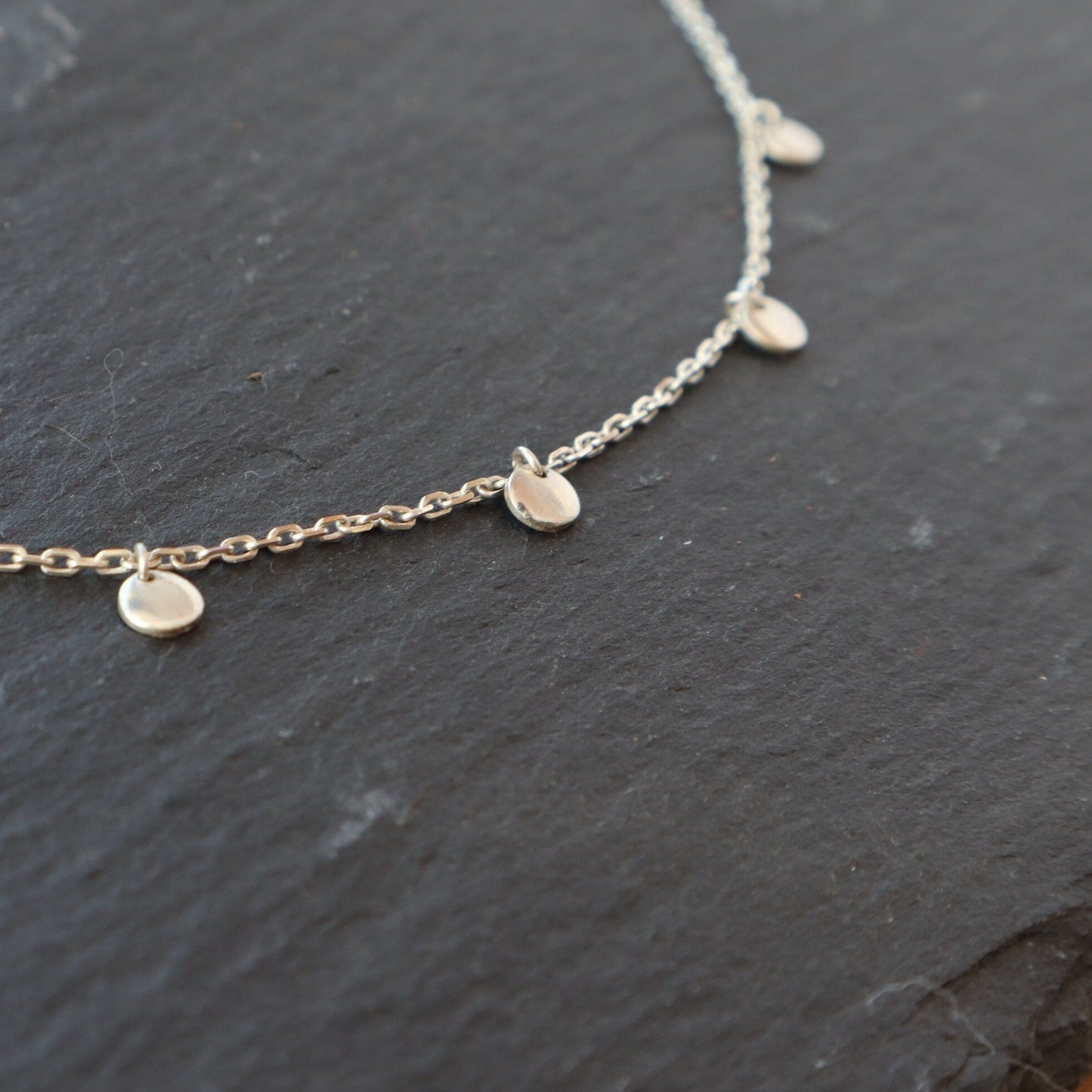 A close up of the sterling silver discs on the satellite choker.